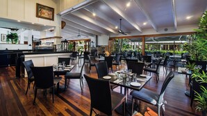 Un restaurante espacioso con techos altos, suelo de madera y diversas opciones de asientos.