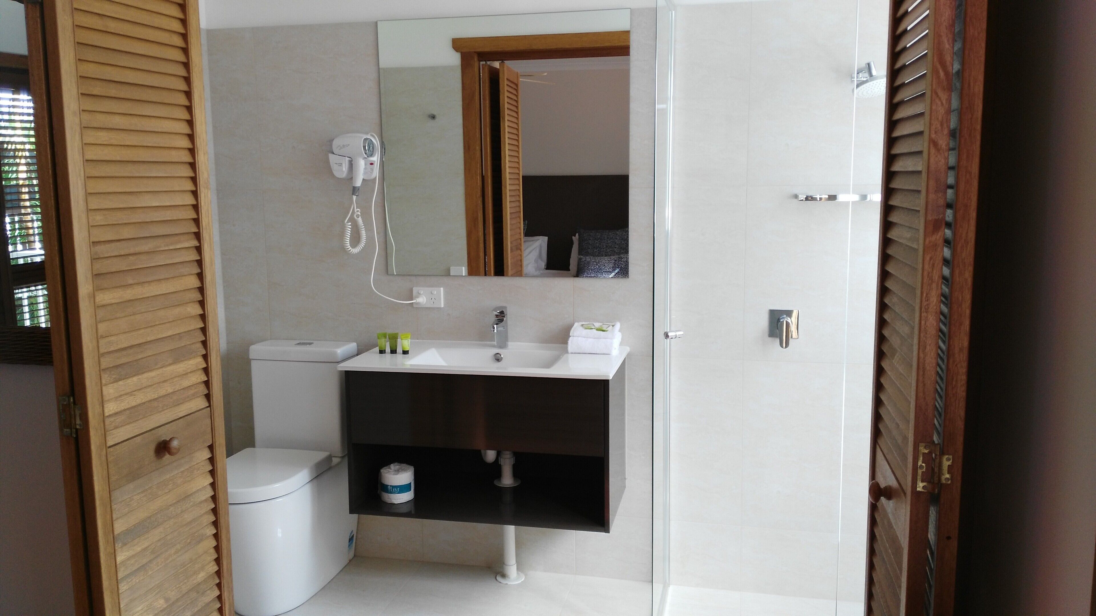 A modern bathroom with a toilet, sink, and shower.