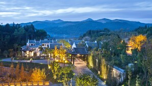 A traditional-style building complex with multiple structures, a central courtyard, and surrounding greenery. - Banyan Tree Tengchong (Baoshan)