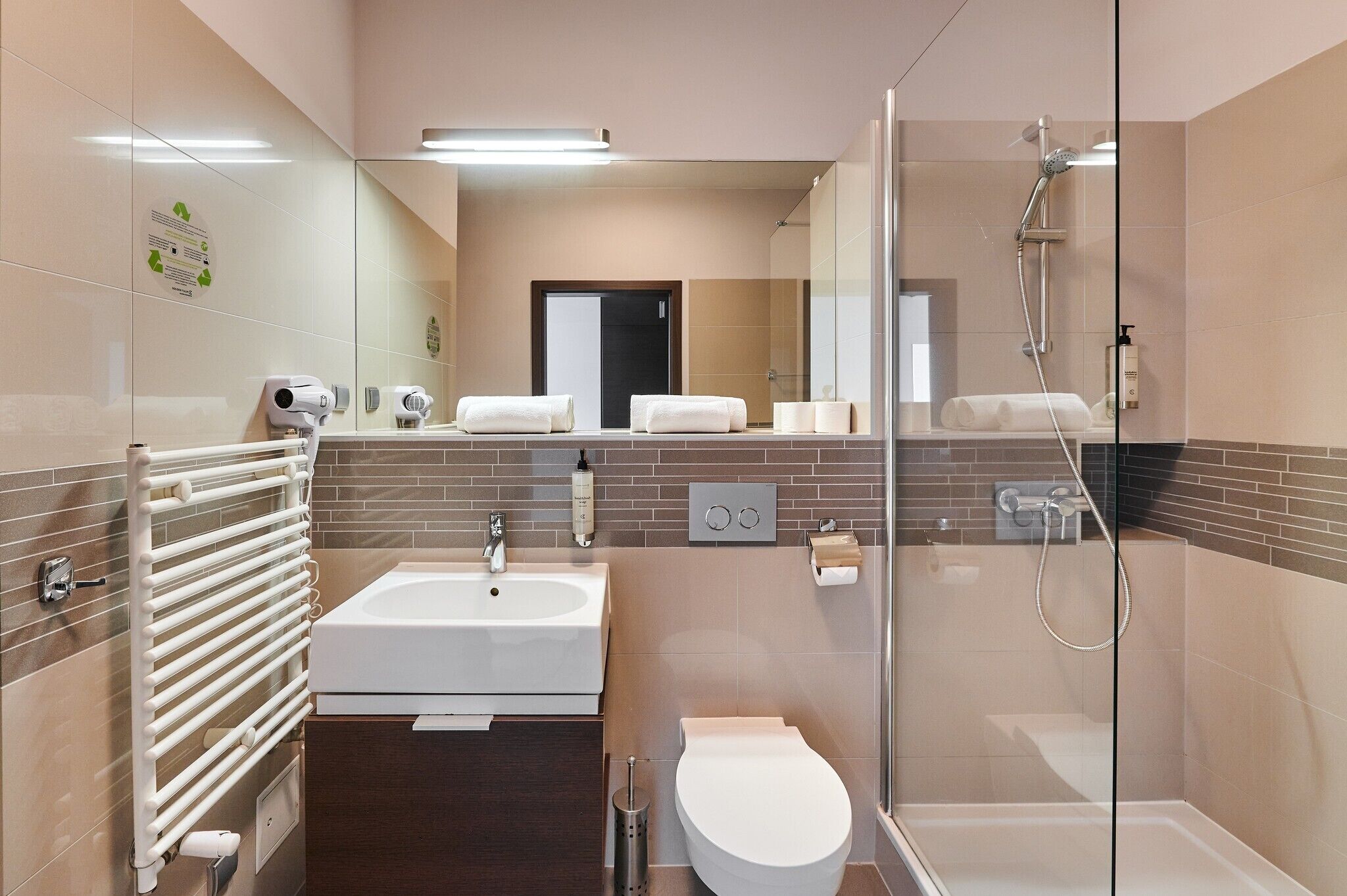 A modern bathroom with a bathtub, toilet, and shower.