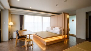 A modern hotel room with a bed, a desk, and a chair. - TATAMI NO YADO Chatan Mihama (Chatan)