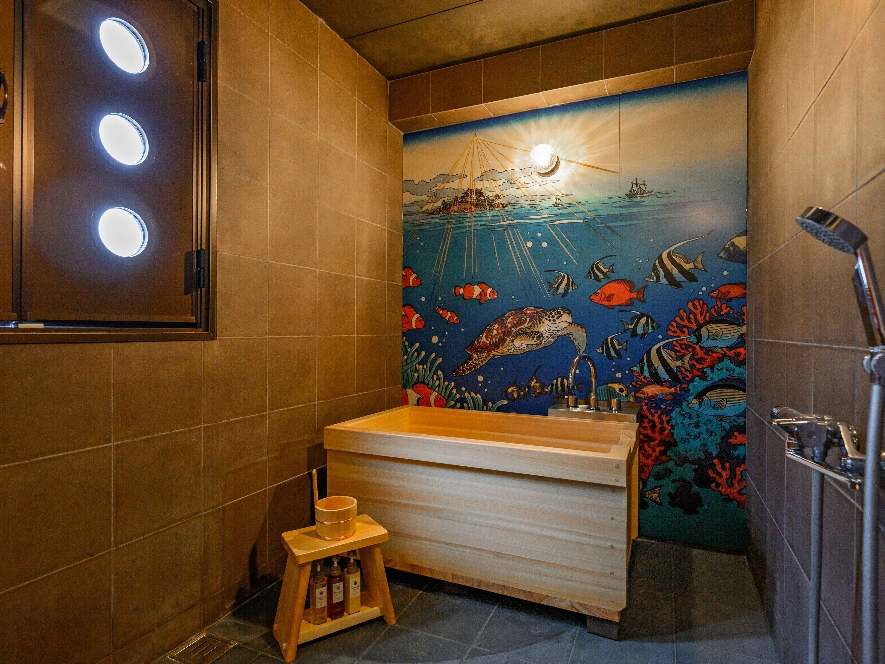 A bathroom with a wooden vanity, a sink, and a wall mural depicting an underwater scene.