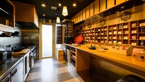 A modern kitchen with stainless steel appliances, wooden cabinets, and a checkered floor. - TATAMI NO YADO Chatan Mihama (Chatan)