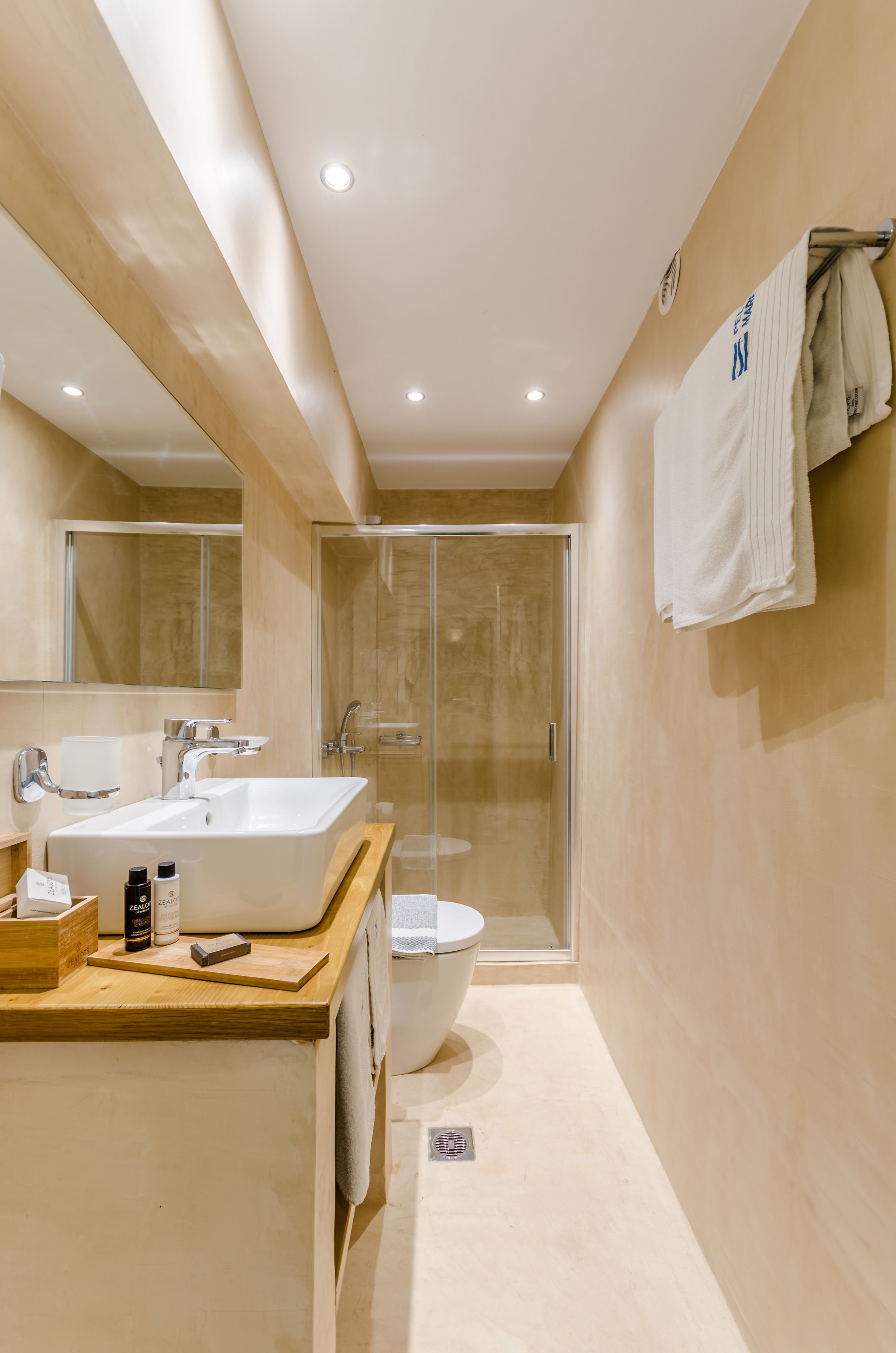 Une salle de bain moderne avec un grand lavabo, un miroir et une douche.
