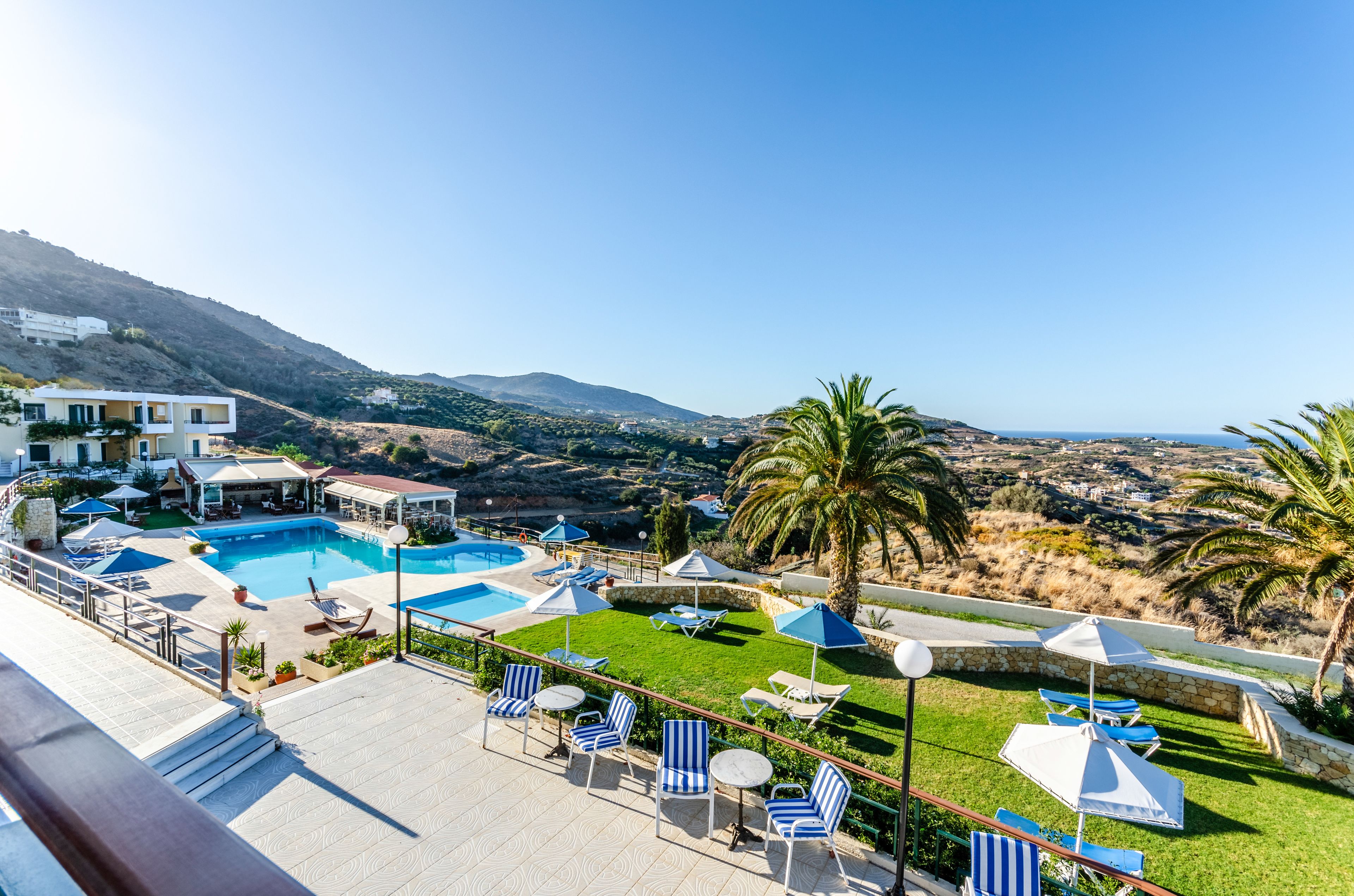 Ein Resort mit Swimmingpool, Liegestühlen und Blick auf die umliegende Landschaft.