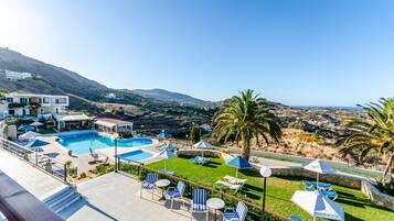 Ein Resort mit Swimmingpool, Liegestühlen und Blick auf die umliegende Landschaft.