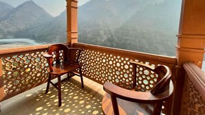 A balcony with two wooden chairs, a lattice partition, and a view of a mountainous landscape. - Raga on the Ganges (Narendranagar)