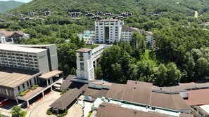 A multi-story hotel with a central tower, surrounded by dense forest. - MONA YongPyong Resort (Pyeongchang)