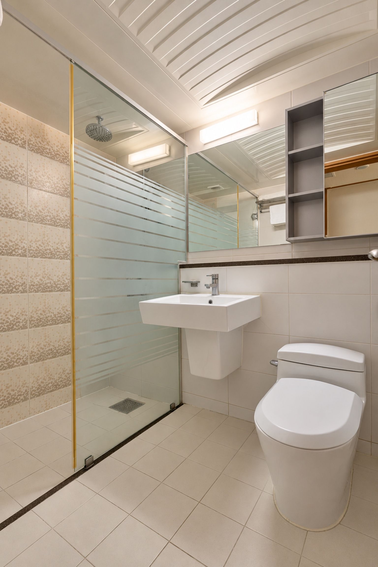 A modern bathroom with a glass shower enclosure, a white sink, and a toilet.
