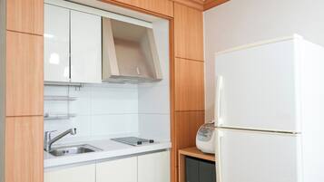 A kitchen with a built-in microwave, a stainless steel sink, and wooden cabinets.