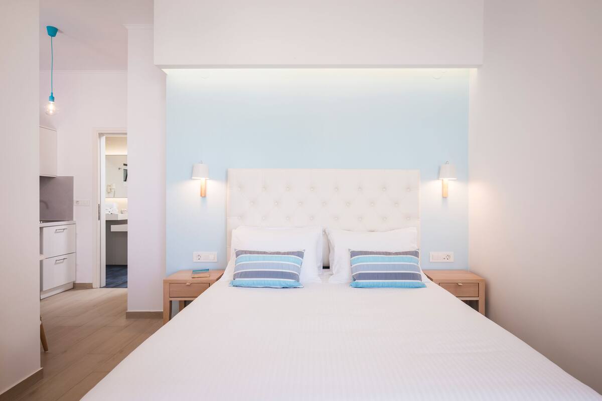 A modern bedroom with a large bed, two bedside tables, and a nightstand.