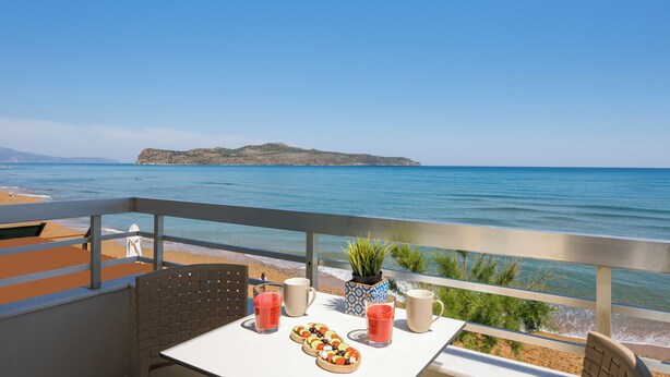 A balcony with a table set for two, overlooking a beach and the sea. - Hermes Beach Front (Chania)