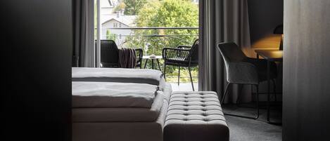 Une chambre d’hôtel avec un lit, un bureau et une vue sur les montagnes.