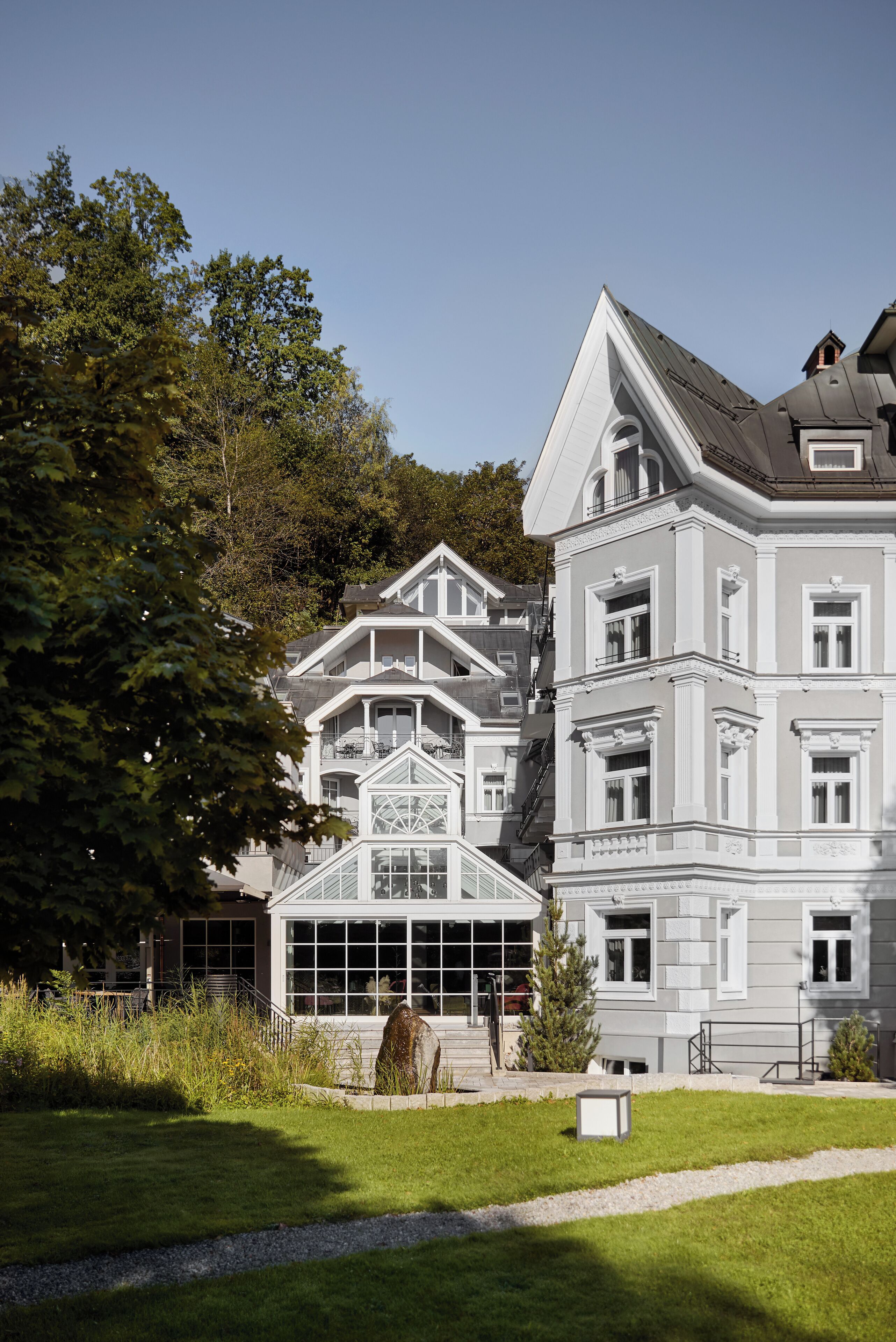 A large, multi-story building with a classic architectural style, featuring a prominent bay window and a symmetrical facade.