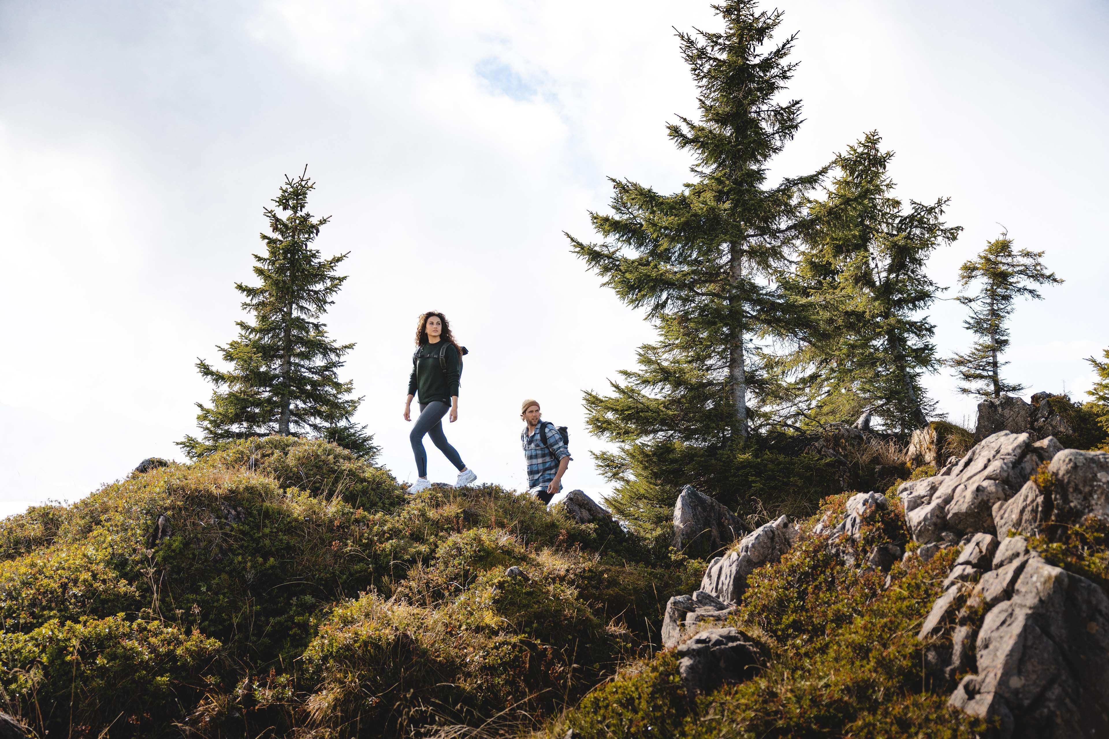 A mountainous landscape with two hikers.