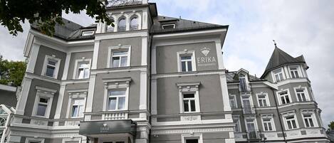 A grand building with a sign reading "ERIKA BOUTIQUE HOTEL".