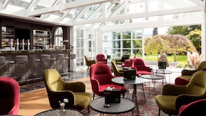 Un bar moderno con asientos y vistas a un jardín.