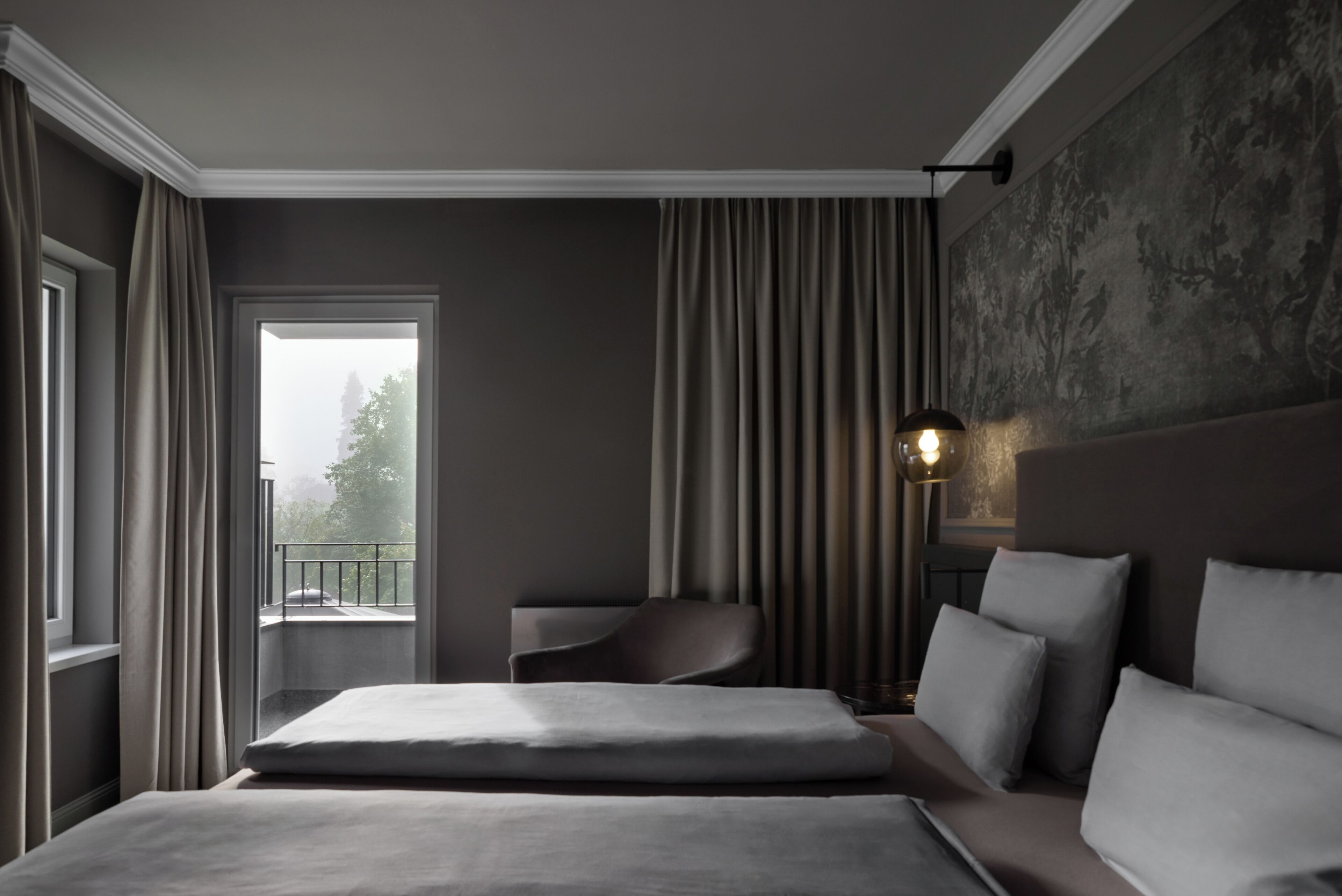 Une chambre d’hôtel moderne, dotée d’un grand lit, d’une chaise et offrant une vue sur l’extérieur par une fenêtre.