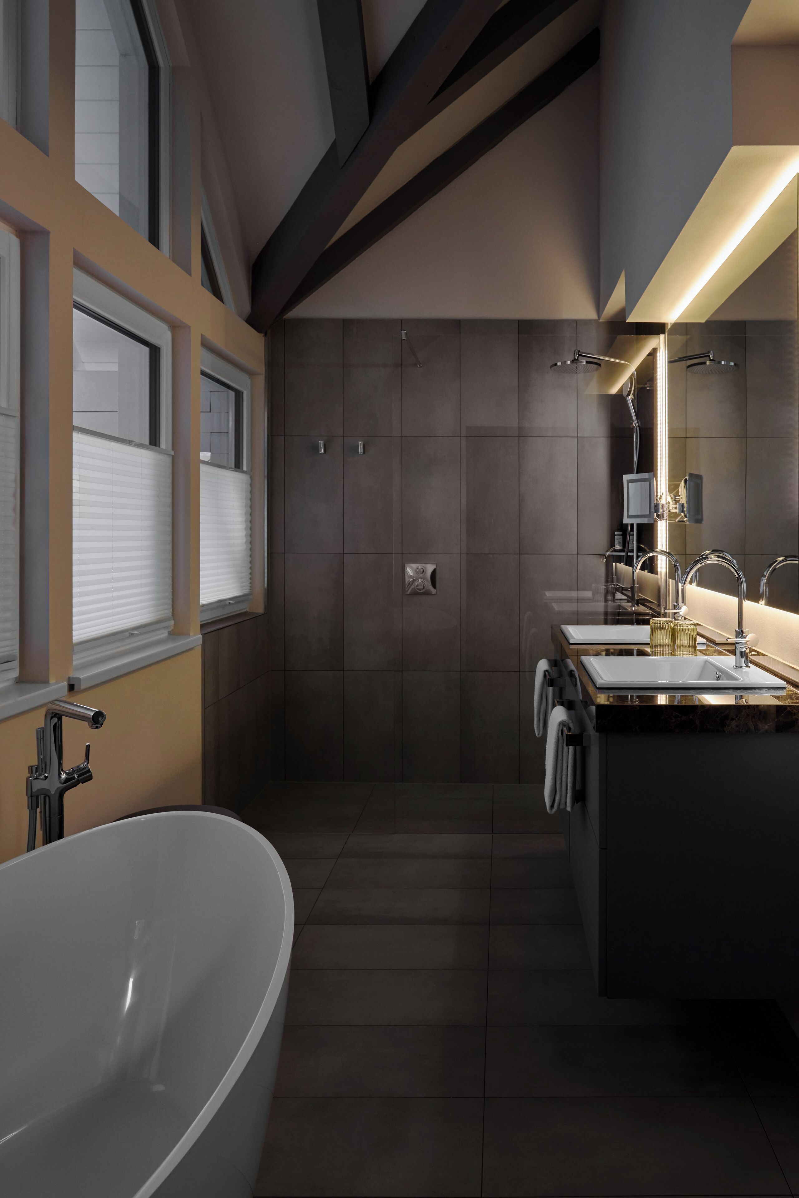 Ein modernes Badezimmer mit freistehender Badewanne, zwei Waschbecken und einer begehbaren Dusche.