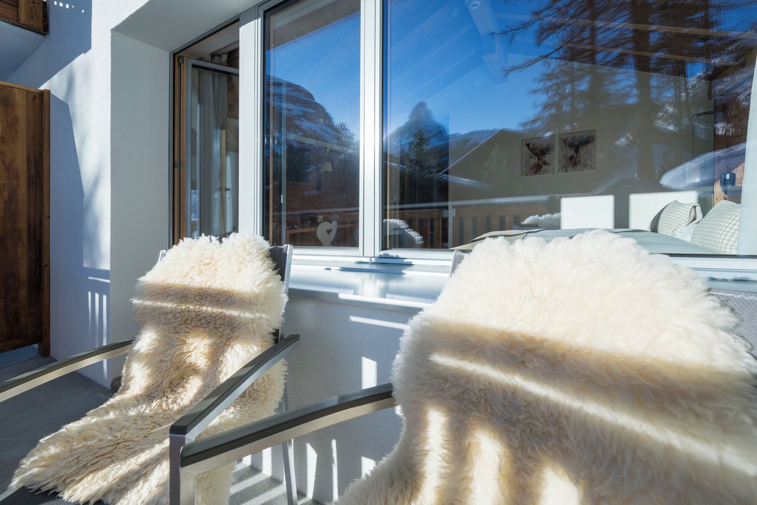 A modern interior with a large window, a glass railing, and a view of the outdoors.