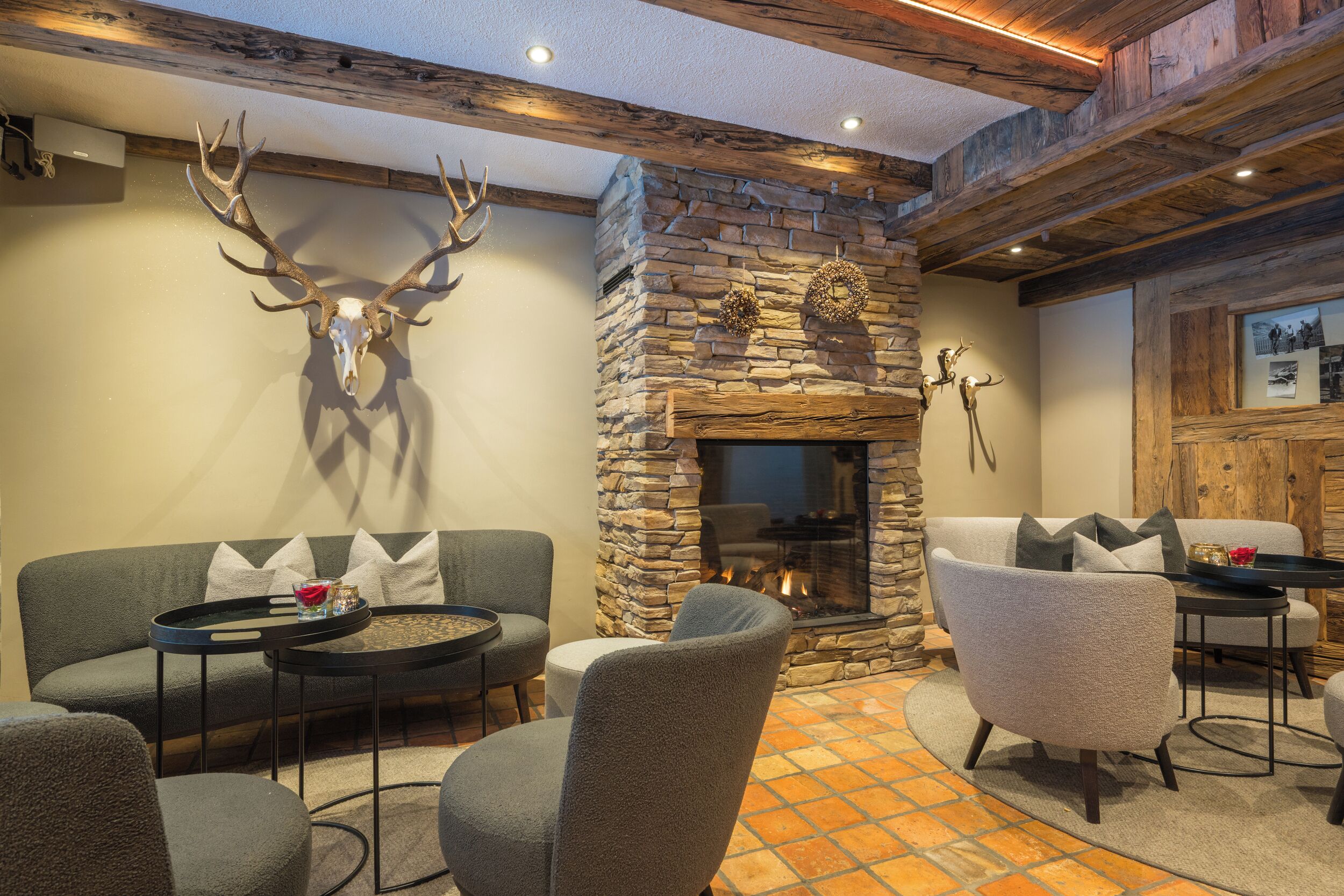 Una sala de estar acogedora con chimenea de piedra, asientos cómodos y una decoración con cráneo de venado.