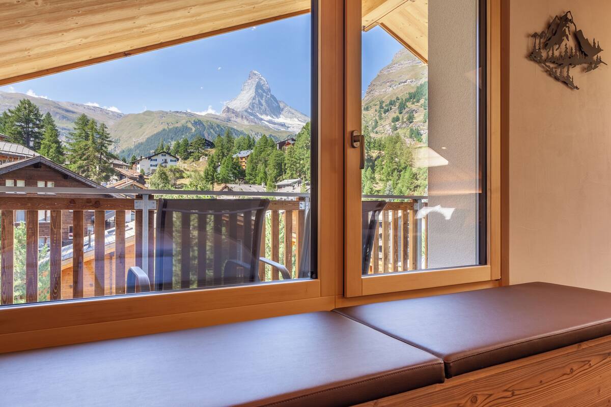 Un banco de madera con vistas a una montaña y casas.