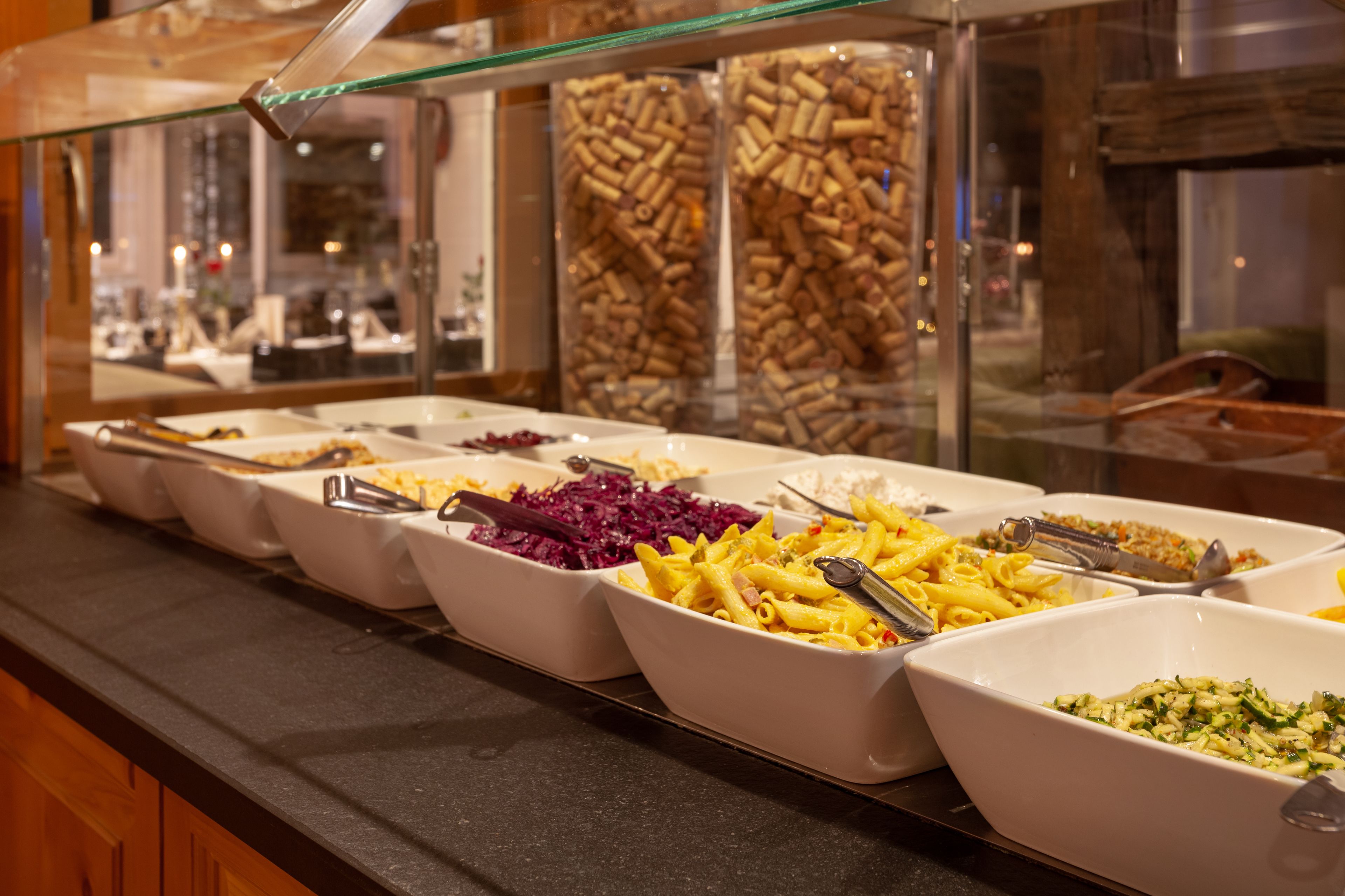 En buffet med et udvalg af retter, herunder pasta, salater og diverse tilberedt mad.