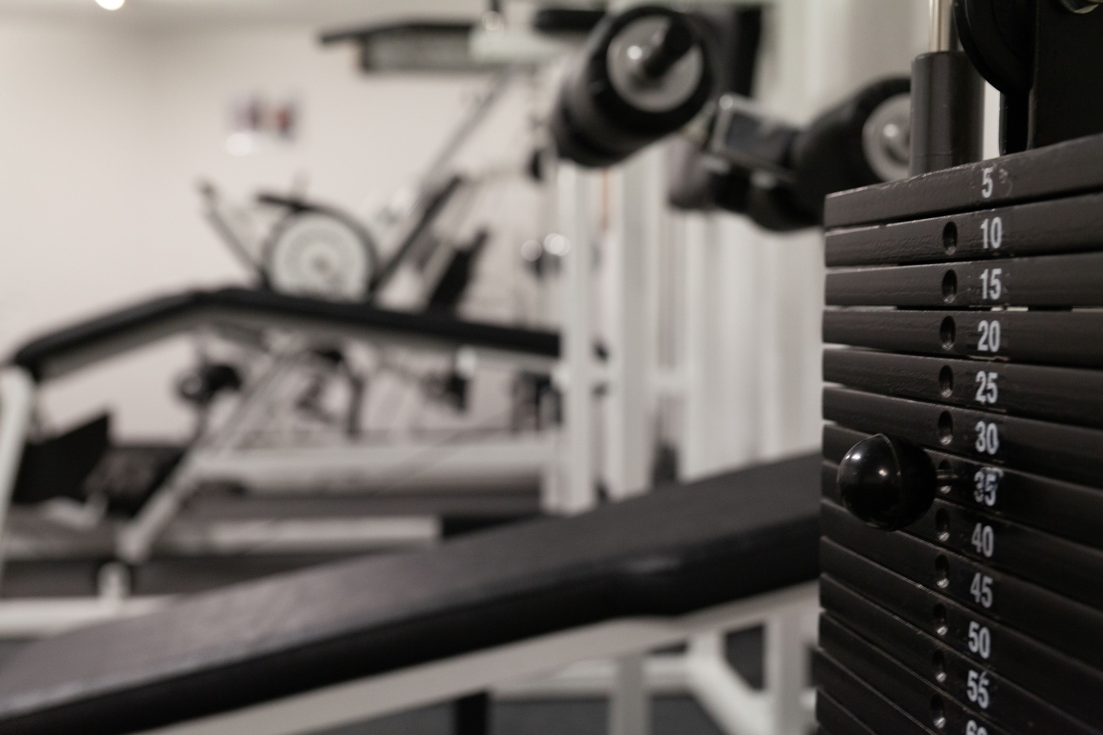 Une salle de sport équipée de machines d'exercice et de poids.
