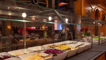 A buffet with various food items in white bowls, a glass display case, and wooden interior decor.