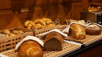 Verschiedene Brotsorten und Gebäck auf Holztabletts.