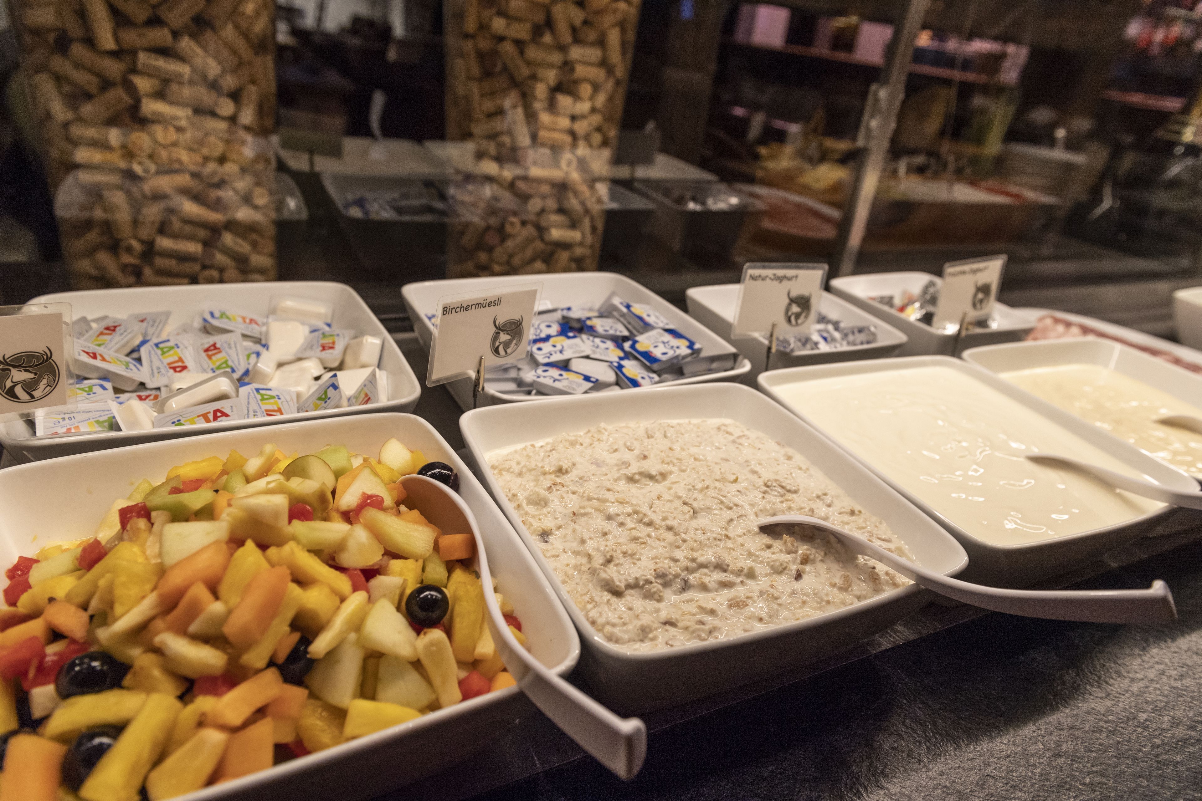 A buffet with various food items including fruits, cheeses, and spreads.