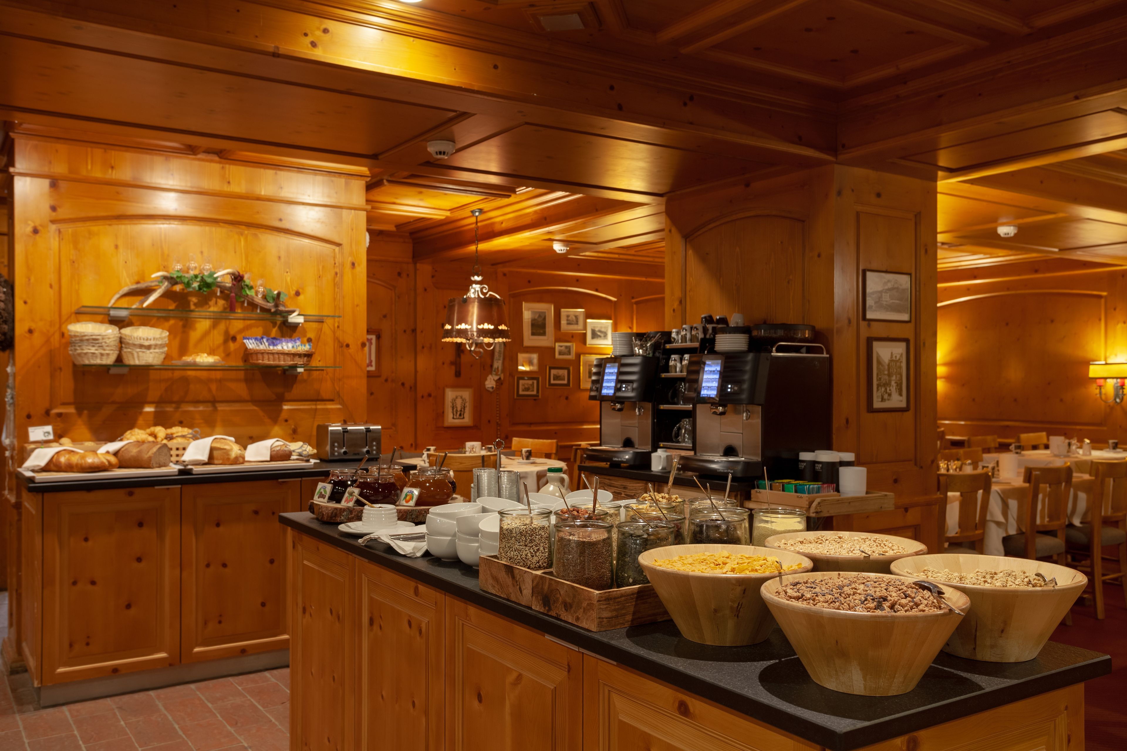 A wooden interior with a buffet counter, wooden cabinets, and a coffee machine.