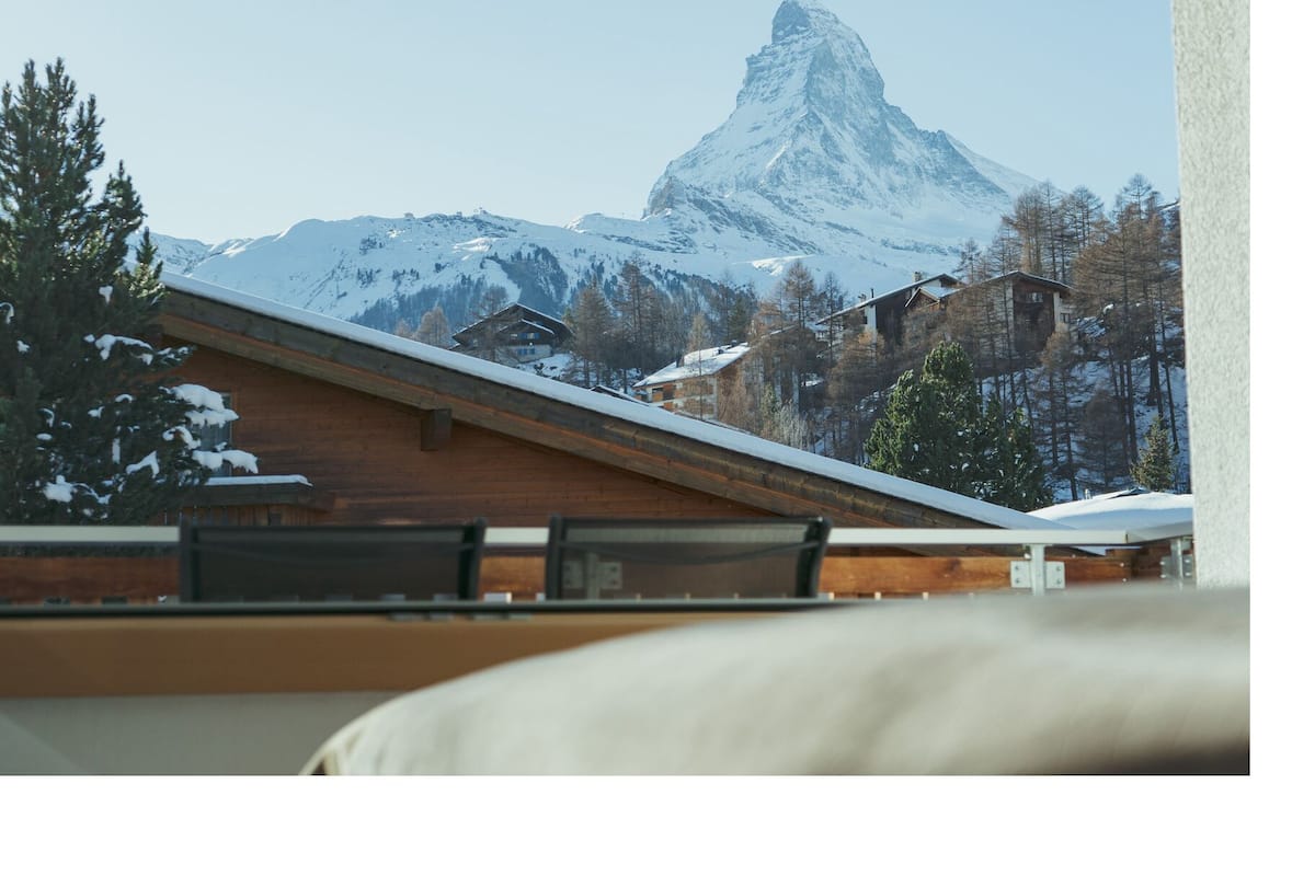 Vista de una montaña con un pico nevado, edificios de madera y un techo de madera.