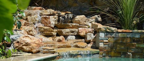 Outdoor pool, a waterfall pool, pool umbrellas, sun loungers