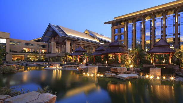 A hotel with a reflective pond, multiple gazebos, and a modern building with large windows. - InterContinental Kunming by IHG (Kunming)