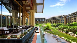 A hotel with outdoor seating, a pool, and a garden. - InterContinental Kunming by IHG (Kunming)