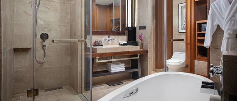 Une salle de bain moderne dotée d’une douche à parois de verre, d’une baignoire sur pied et d’un meuble-lavabo avec un miroir et un porte-serviettes.