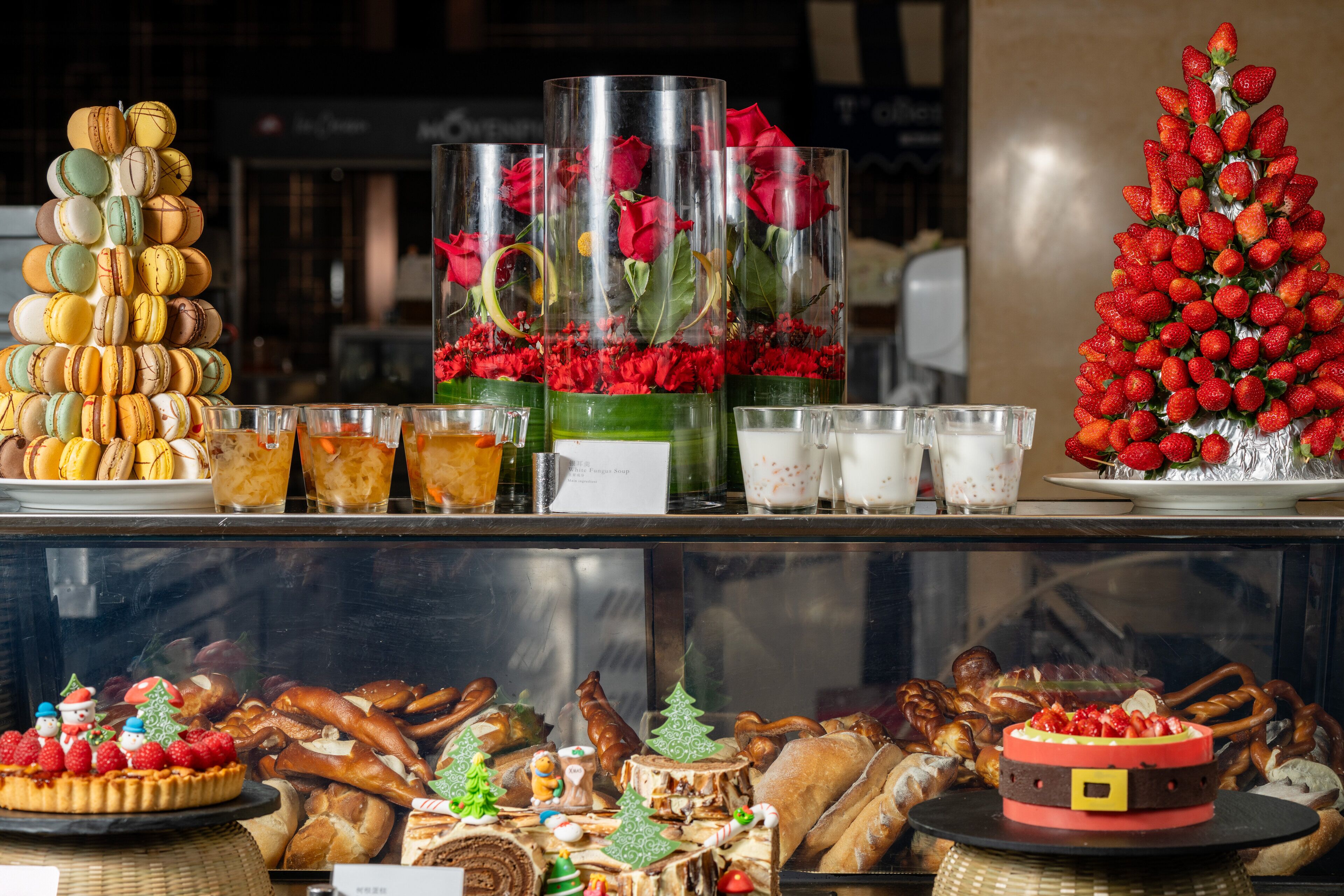 A display of pastries, desserts, and beverages in a bakery or cafe setting.