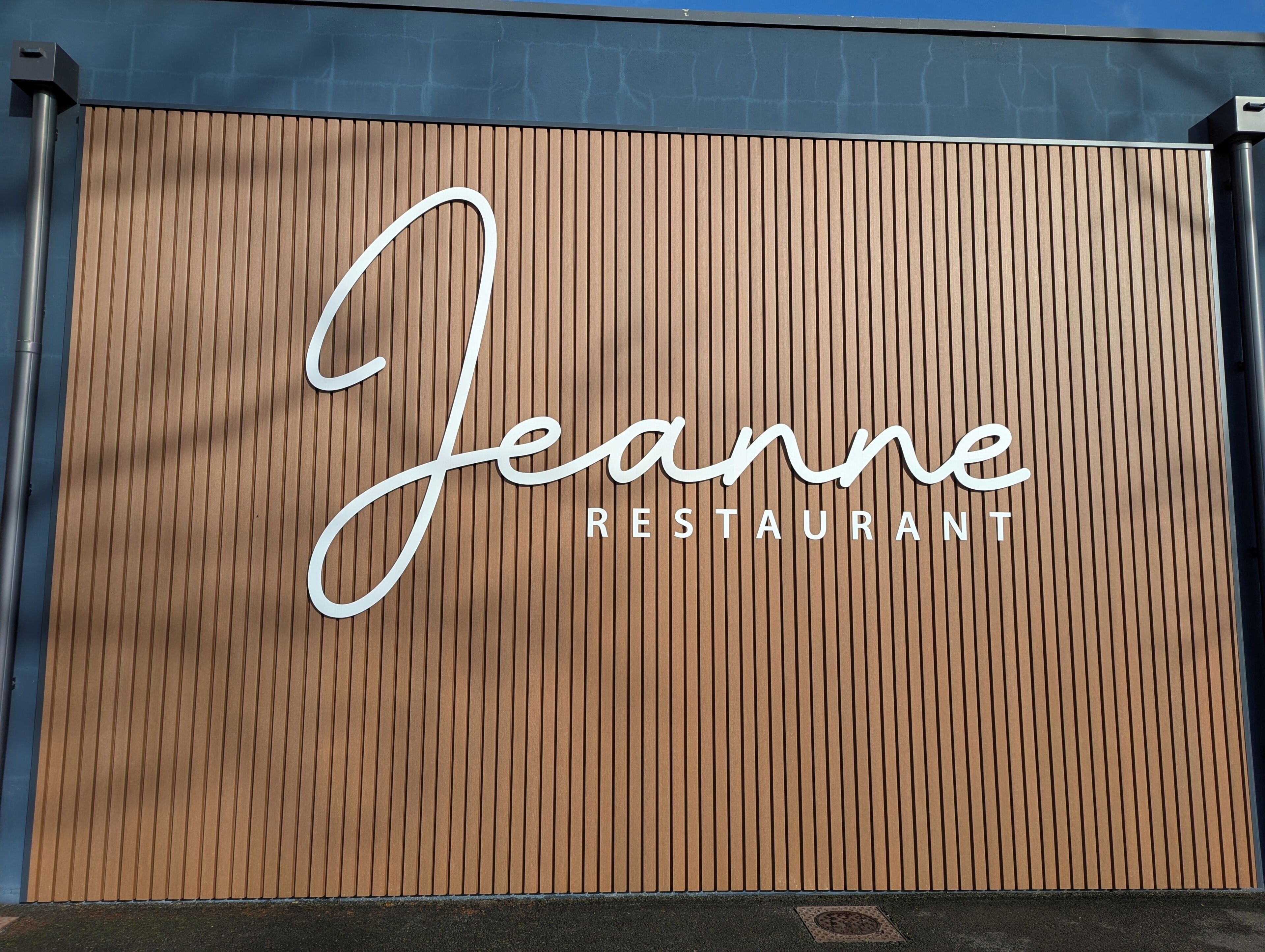 A restaurant sign with the name 'Jeanne' and the word 'RESTAURANT' below it.