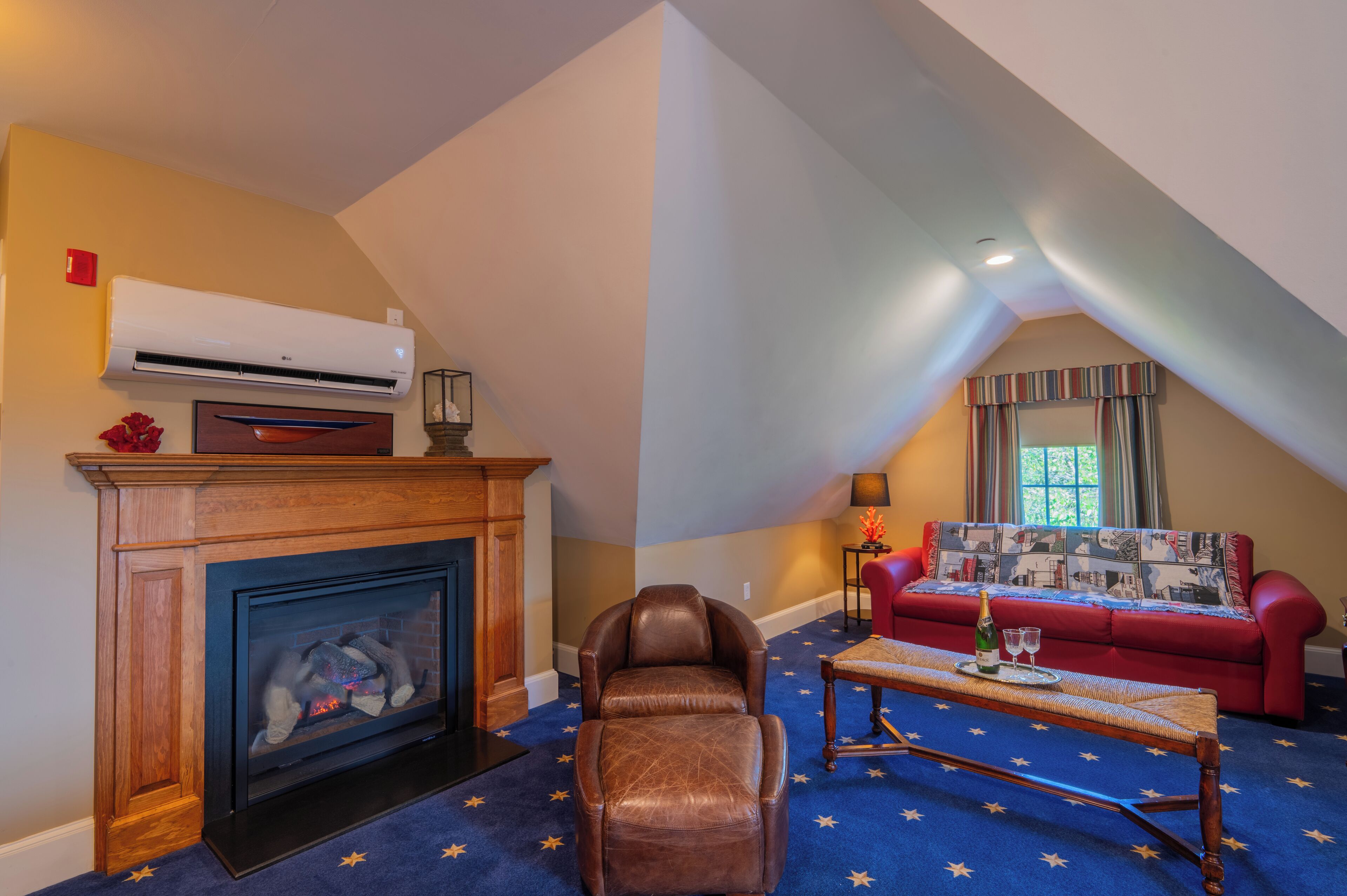 A cozy living room with a fireplace, leather armchair, and a red sofa.