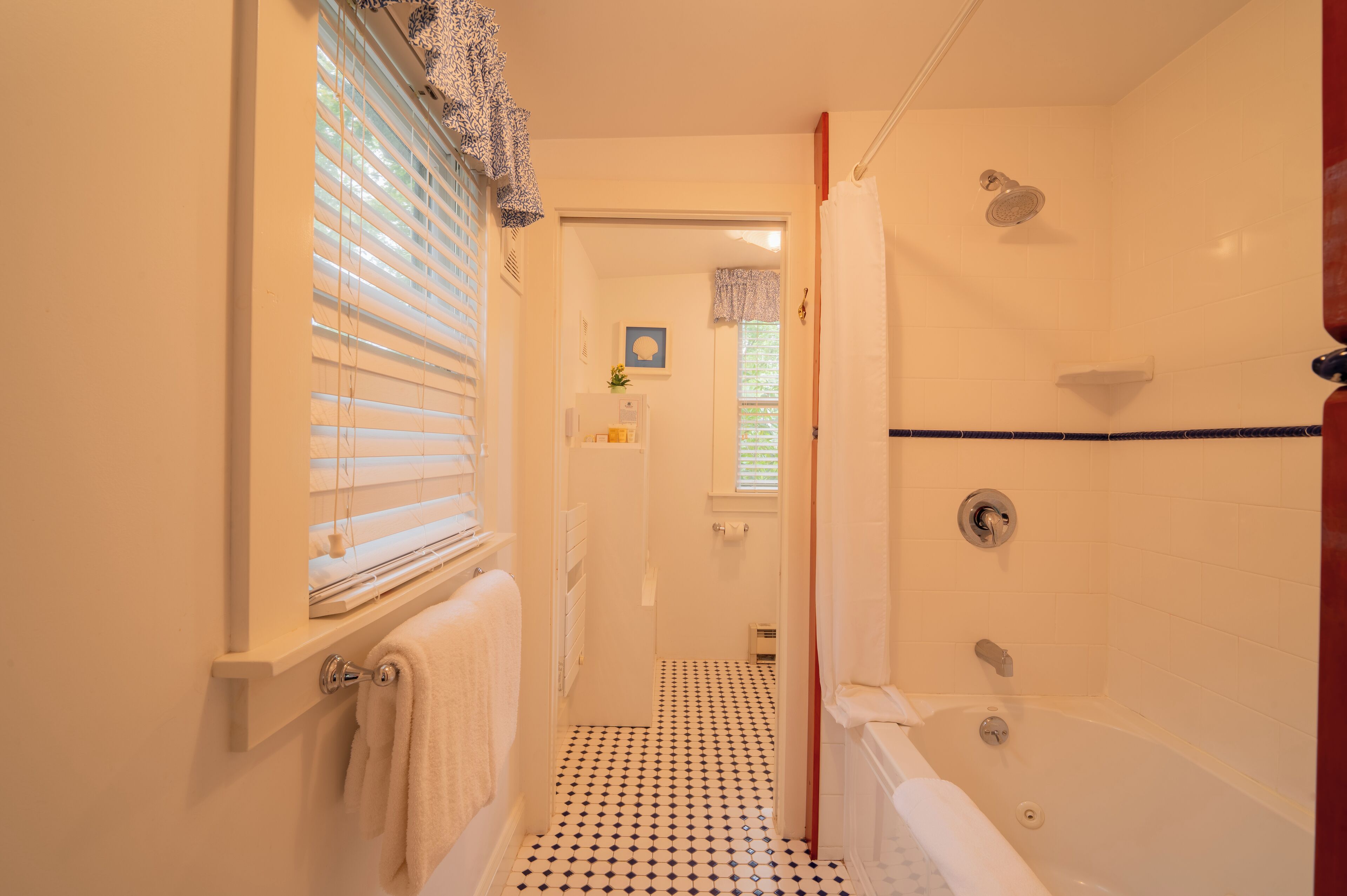Et badeværelse med bruser, badekar og toilet.