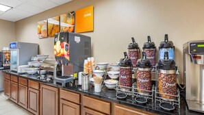 Un coin café équipé de plusieurs distributeurs étiquetés « Corsé », « Normal » et « Décaféiné ». On y trouve également des bols de crème et une machine à café en arrière-plan.
