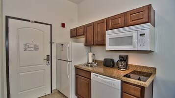 A compact kitchen with a microwave, toaster, and dishwasher.
