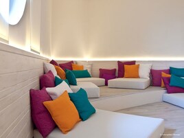 Ein stilvoller Lounge-Bereich mit weißen Sofas und farbenfrohen Kissen.