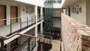 A multi-level interior with wooden staircases, metal railings, and a brick wall. - Zollenspieker Fährhaus (Hamburg)