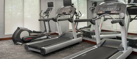 A gym with treadmills, ellipticals, and a stationary bike.