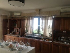 A breakfast buffet with various food items and a window with curtains. - CapoSperone Resort (Palmi)