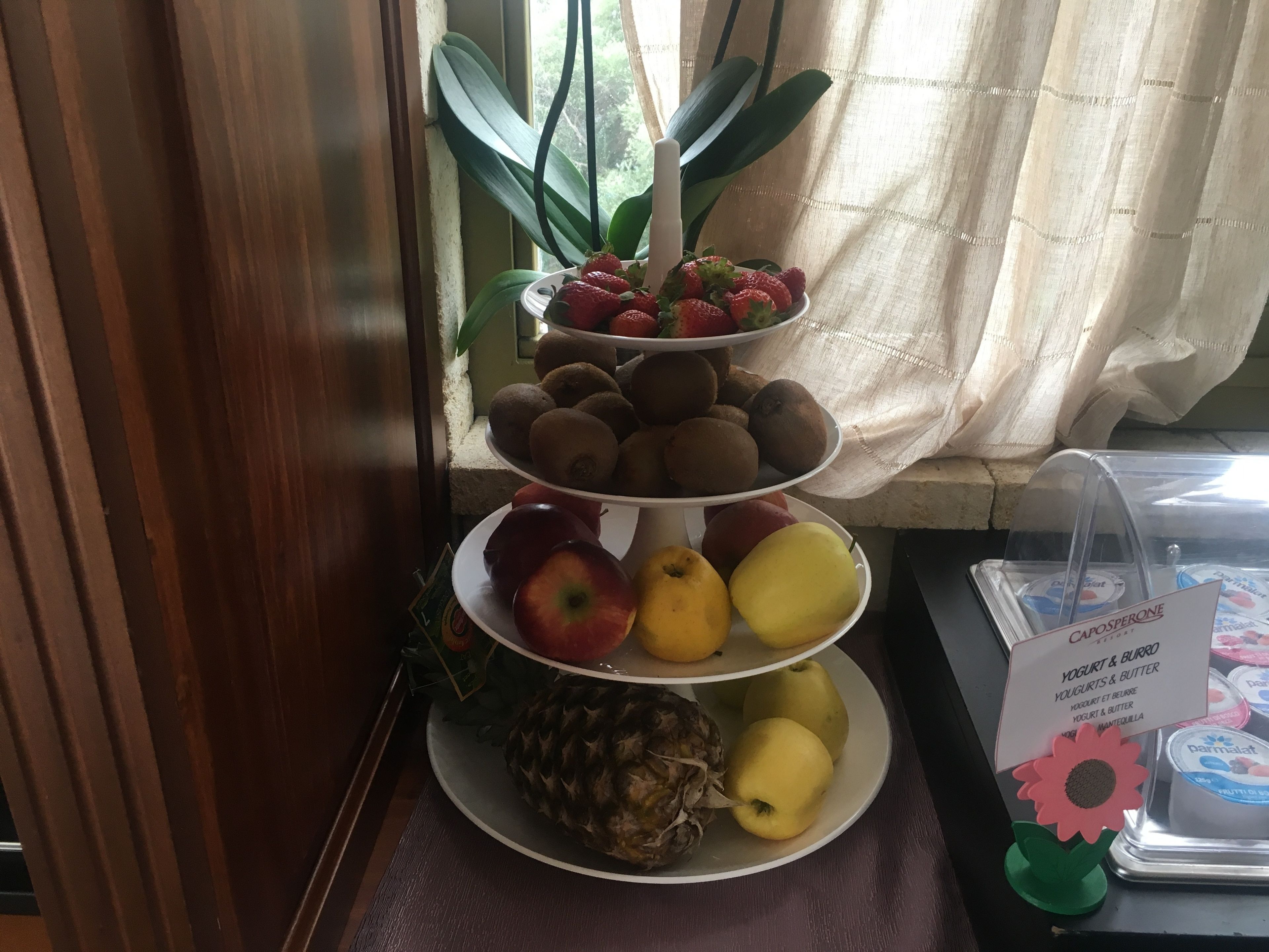 A fruit display with kiwis, strawberries, apples, pears, and a pineapple.