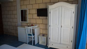 Une chambre à coucher comprenant un lit, un bureau avec une chaise, une armoire et une petite table.