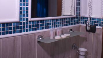 A bathroom with a sink, mirror, and hair dryers.